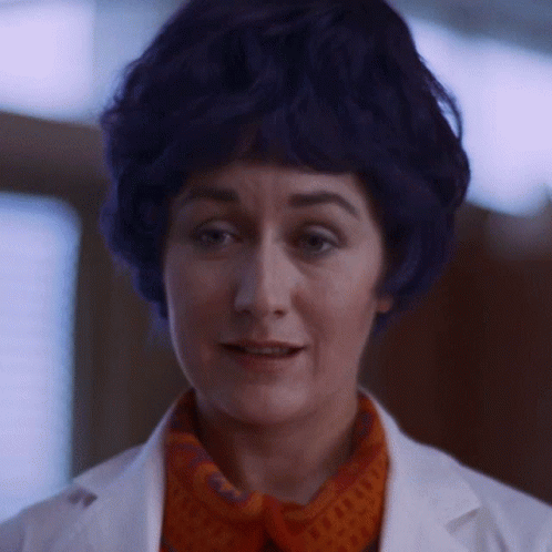 A Woman With Blue Hair Is Wearing A White Coat GIF
