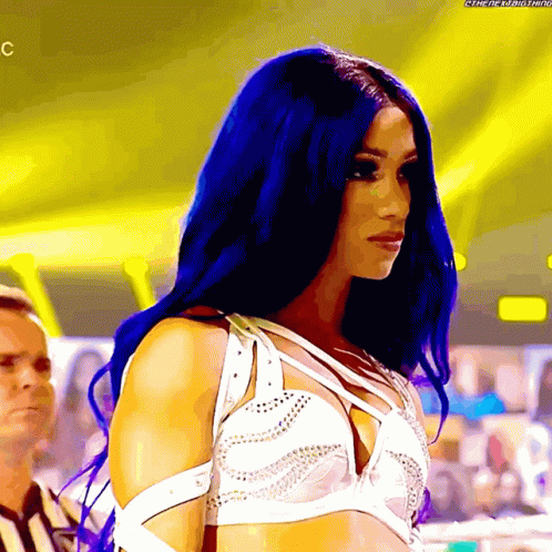 a woman with blue hair is wearing a white top with studs