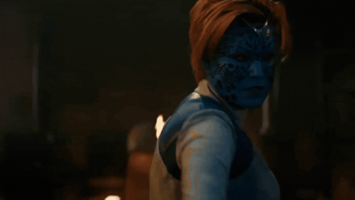 A Woman With Blue Paint On Her Face Is Holding A Sword GIF