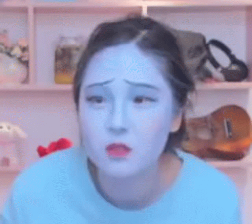 A Woman With Blue Paint On Her Face Looks Sad . GIF