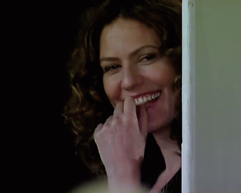 A Woman With Braces On Her Teeth Is Laughing GIF