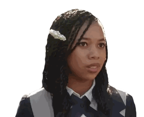 a woman with braids and a pearl clip in her hair looks at the camera