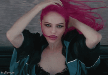 a woman with bright pink hair is wearing a blue jacket