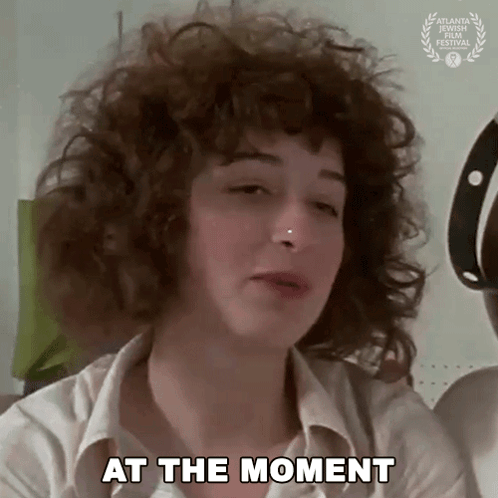 Woman With Curly Hair And Nose Ring Saying At The Moment GIF