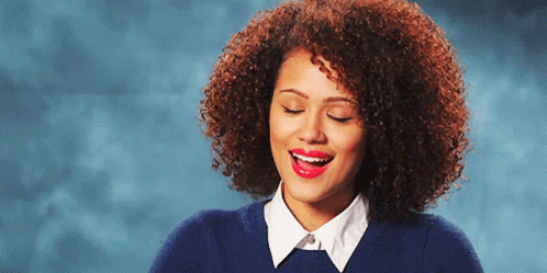 A Woman With Curly Hair And Red Lipstick Is Smiling GIF