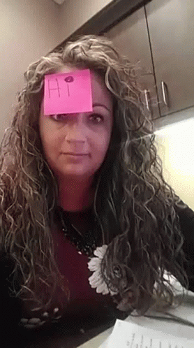 A Woman With Curly Hair Has A Sticky Note On Her Forehead That Says Hi GIF