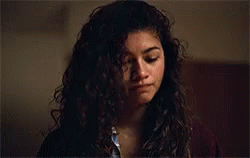 a woman with curly hair is looking down at something