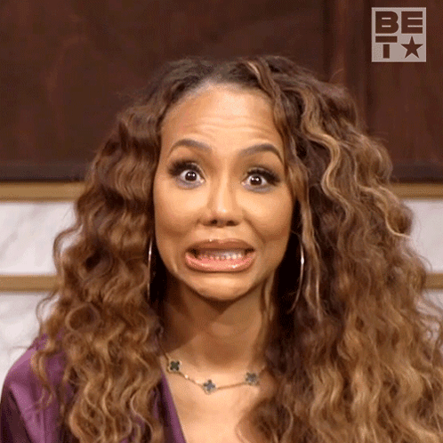 A Woman With Curly Hair Is Making A Funny Face While Wearing A Necklace . GIF