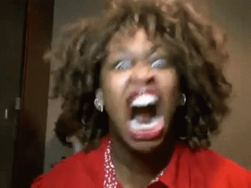 A Woman With Curly Hair Is Screaming With Her Mouth Open . GIF