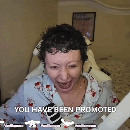 A Woman With Curly Hair Is Smiling And Holding A Microphone With The Words " You Have Been Promoted " Above Her GIF