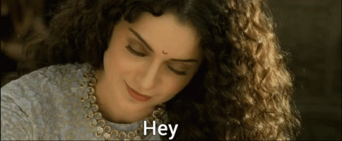 A Woman With Curly Hair Is Smiling And The Word Hey Is On The Bottom GIF