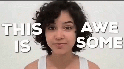A Woman With Curly Hair Is Standing In Front Of A White Background With The Words `` This Awe Is Some '' . GIF