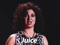 A Woman With Curly Hair Is Wearing A Black And White Dress And Necklace And Says Juice . GIF