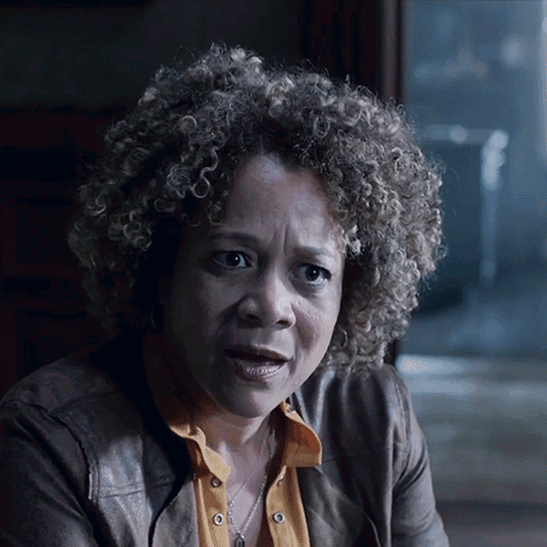 A Woman With Curly Hair Is Wearing A Leather Jacket GIF