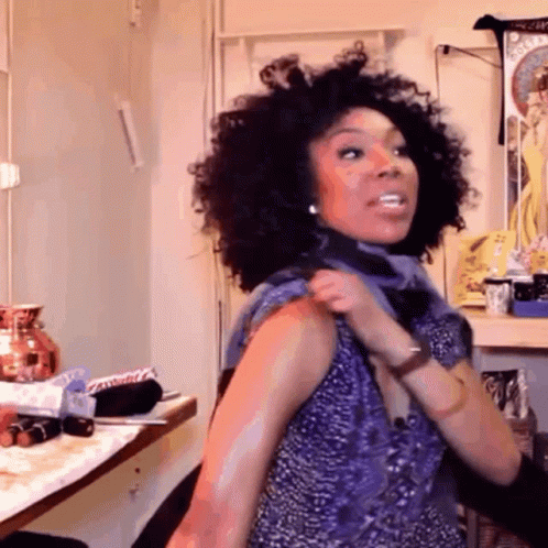 Woman With Curly Hair Wearing Purple Top GIF