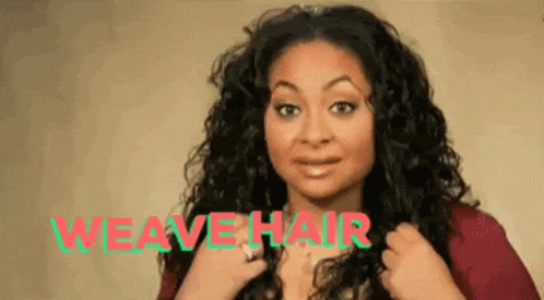 A Woman With Curly Hair Is Wearing A Red Shirt And Holding Her Hair In Front Of The Words `` Weave Hair '' . GIF