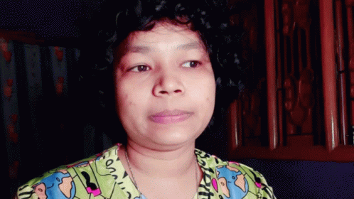 A Woman With Curly Hair Is Wearing A Shirt That Says ' On ' On The Front GIF