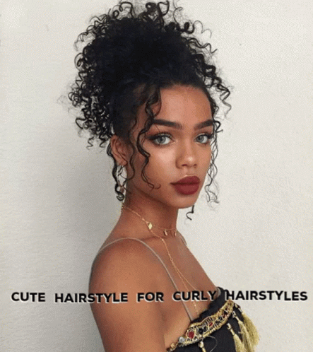 A Woman With Curly Hair Is Wearing A Top And A Necklace GIF
