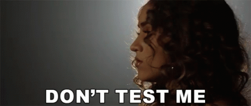 A Woman With Curly Hair Says " Do N't Test Me " In White Letters GIF