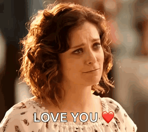A Woman With Curly Hair Says Love You With A Red Heart GIF