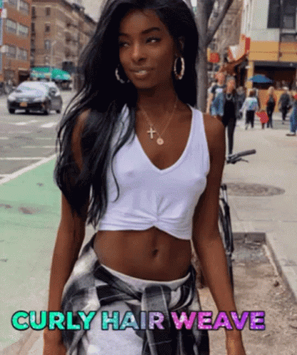A Woman With Curly Hair Wearing A White Tank Top And Plaid Skirt GIF