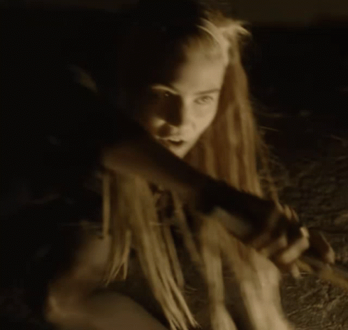 A Woman With Dreadlocks Is Holding A Candle In Her Hand GIF