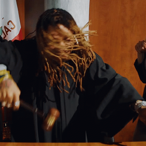A Woman With Dreadlocks Is Holding A Hammer In Front Of A Flag That Says " California " GIF
