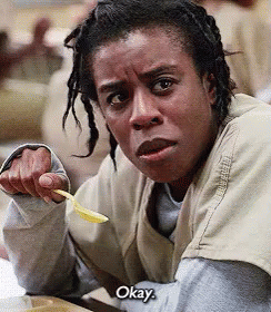 a woman with dreadlocks is holding a spoon and says okay .