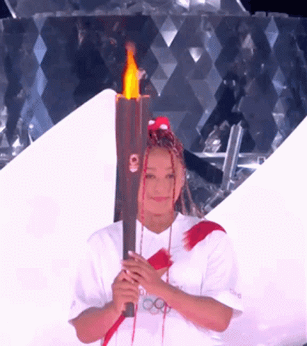 A Woman With Dreadlocks Is Holding A Torch That Says Tokyo On It GIF