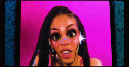 A Woman With Dreadlocks Is Looking At The Camera With A Pink Background . GIF