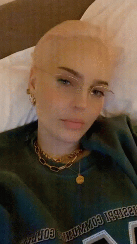 A Woman With Glasses And A Green Shirt That Says Columbia GIF