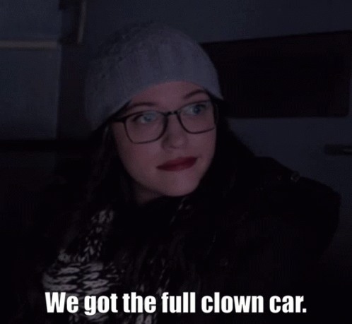 A Woman With Glasses And A Hat Says We Got The Full Clown Car GIF