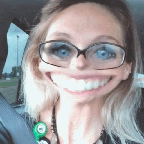 A Woman With Glasses And A Stethoscope Around Her Neck Smiles For The Camera GIF