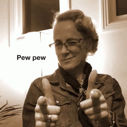 A Woman With Glasses Giving A Thumbs Up With Pew Pew Written Above Her GIF