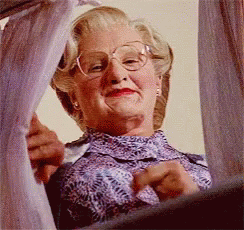 A Woman With Glasses Is Looking Out A Window GIF