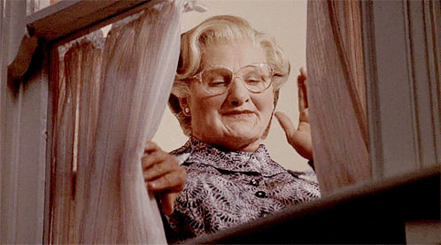A Woman With Glasses Looks Out A Window GIF