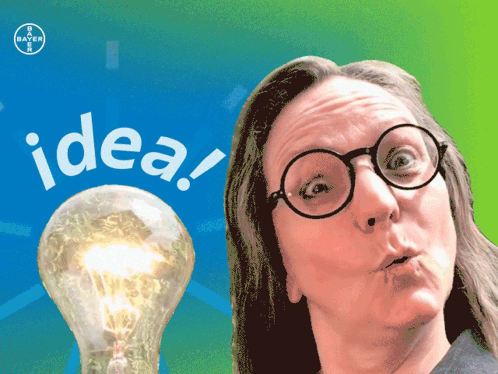 A Woman With Glasses Stands In Front Of A Light Bulb That Says Idea On It GIF