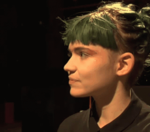 A Woman With Green Hair And A Black Shirt GIF