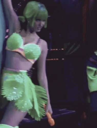 A Woman With Green Hair Is Wearing A Green Dress GIF