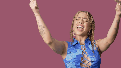 A Woman With Her Arms In The Air With Yas Queen Written On The Bottom GIF