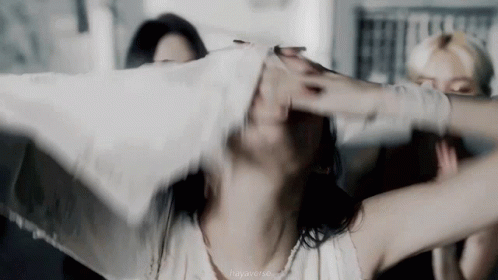 A Woman With Her Arms Outstretched Is Holding A White Cloth Over Her Head . GIF