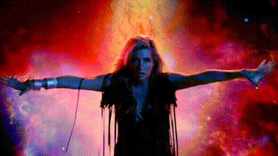 A Woman With Her Arms Outstretched Is Standing In Front Of A Galaxy . GIF