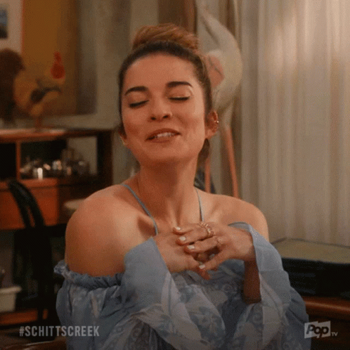 A Woman With Her Eyes Closed And The Word Schittscreek Written On The Bottom GIF