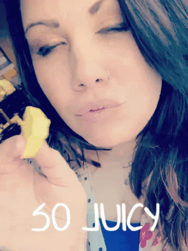 A Woman With Her Eyes Closed Is Holding A Piece Of Food With The Words So Juicy Written On The Bottom GIF