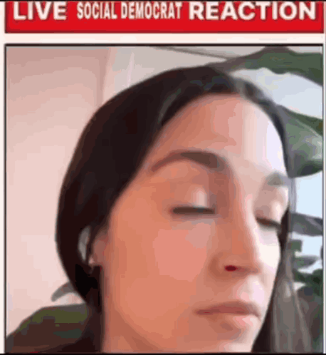 A Woman With Her Eyes Closed Is In Front Of A Sign That Says Live Social Democrat Reaction . GIF