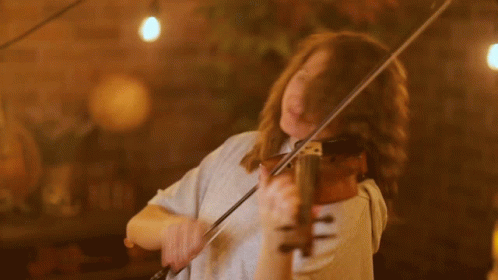 A Woman With Her Eyes Closed Is Playing A Violin GIF