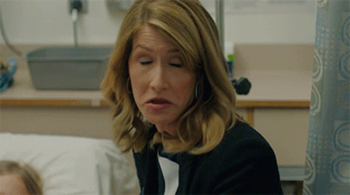 A Woman With Her Eyes Closed Is Sitting In A Hospital Room GIF