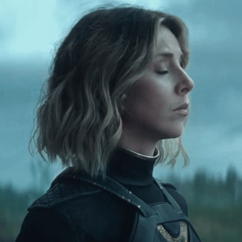 A Woman With Her Eyes Closed Is Wearing A Black Top GIF