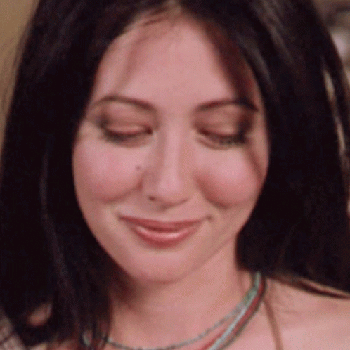 A Woman With Her Eyes Closed Is Wearing A Necklace GIF