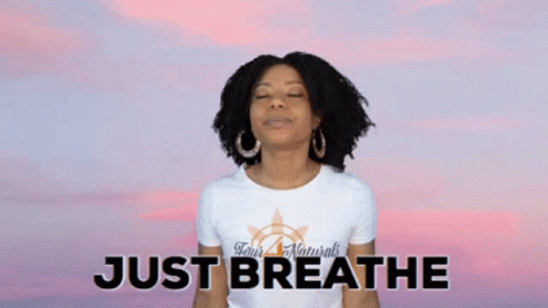 A Woman With Her Eyes Closed Is Wearing A Shirt That Says Just Breathe . GIF